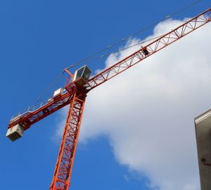 sopraelevazione condominiale, gru rossa a lavoro vicino al tetto di un condominio