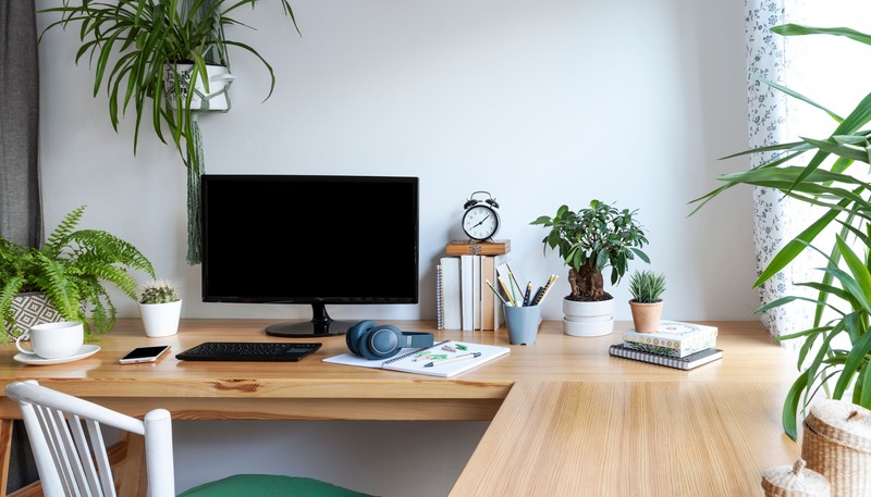 angolo studio di design scrivania vicino ad una finestra con pc e decorazioni