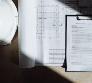 Aggiornamento catastale con DOCFA: i casi in cui serve davvero: Vista dall'alto di documenti di costruzione e casco alla…