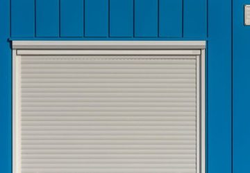 Tapparelle pulite senza smontarle con un lavaggio semplice: Un muro blu moderno con un saracinesca bianca chiusa, perfetto…